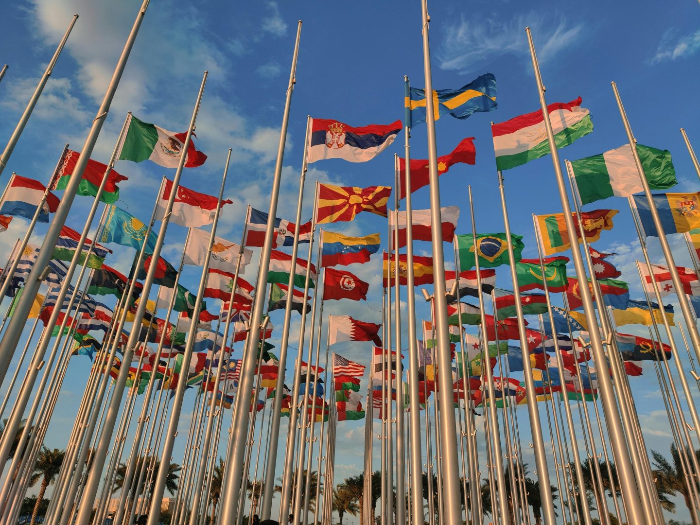 Global flags against a blue sky.